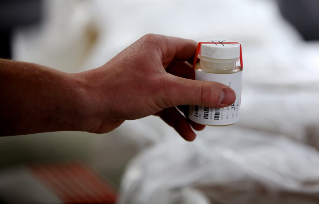 A Marine holds a urine sample in a white bottle with a barcode on its label during a II Marine Expeditionary Force-wide drug test at Marine Corps Base Camp Lejeune, N.C. (Marine Corps photo/Daniel A. Wulz)